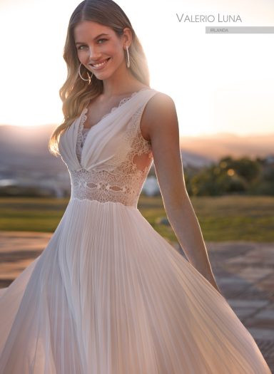Novias Mujer sonriente luciendo un vestido de novia elegante en un entorno al aire libre.